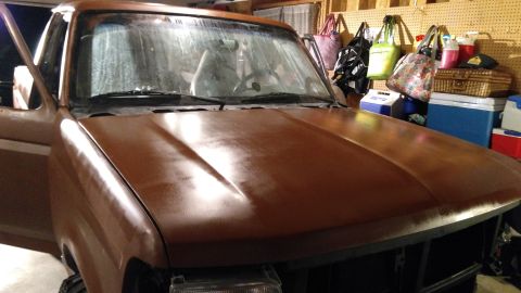 1996 Ford Bronco - Front view of a brown Ford Bronco, likely undergoing restoration, with garage items in the background.