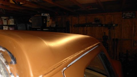 1996 Ford Bronco - The top of a vehicle is shown in a garage, with a Ford logo visible on the wall.