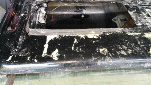 1996 Ford Bronco - The black tailgate shows significant peeling paint, revealing exposed metal underneath. This part is from a vehicle undergoing body work.