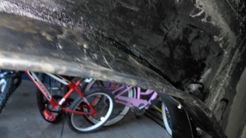 1996 Ford Bronco - Several bicycles are stored underneath a dark, textured surface, possibly the undercarriage of a vehicle.