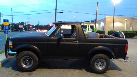 1996 Ford Bronco - This black Ford Bronco is viewed from its side, showing its removable top and off-road tires.