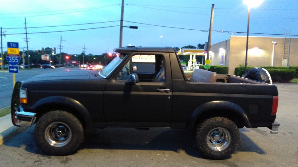 Black Ford Bronco with a removable top, seen from the side