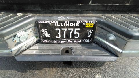 1996 Ford Bronco - The rear bumper of a vehicle displays an Illinois license plate and a trailer hitch.