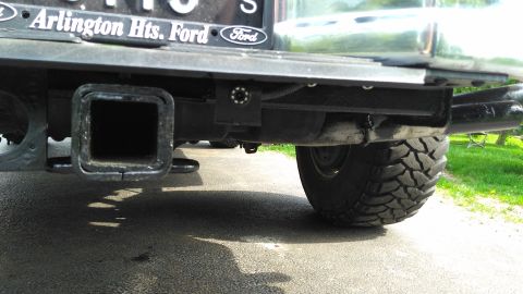 1996 Ford Bronco - Close-up of a trailer hitch and backup camera mounted on the rear bumper of a vehicle.