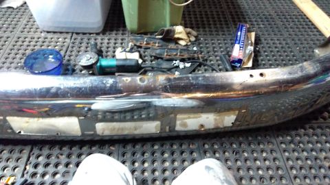 1996 Ford Bronco - Chrome bumper part with tools laid out on a textured mat, ready for work.