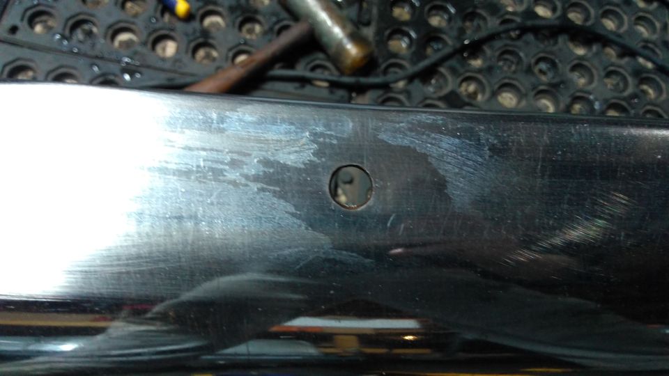 Chrome bumper section with a hole and scuff marks