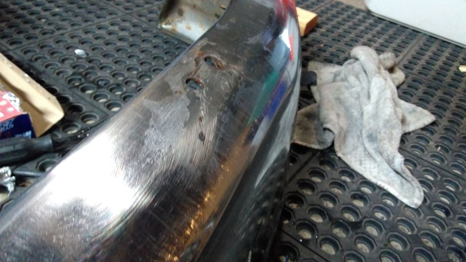 chrome bumper with some dents and scratches, rag on the side