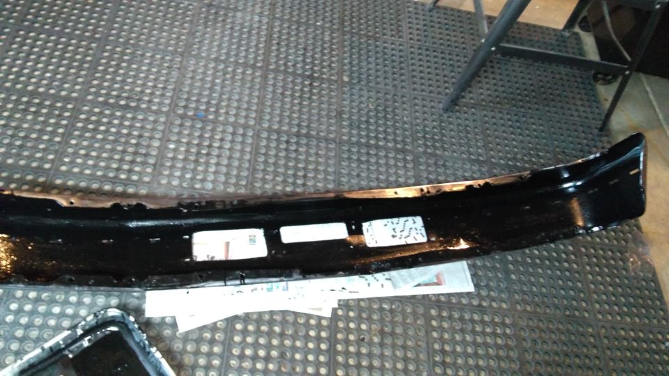 Black front bumper with three rectangular cutouts, resting on a mat