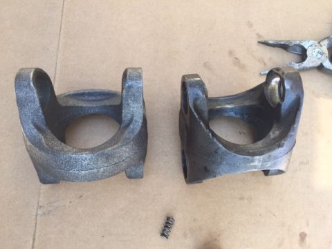 1978 Ford Bronco - Comparison of a new driveshaft yoke next to a used one, with a small spring and pliers visible.