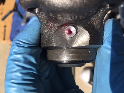 1978 Ford Bronco - Gloved hand holds a metal part with a visible grease fitting, likely for maintenance.