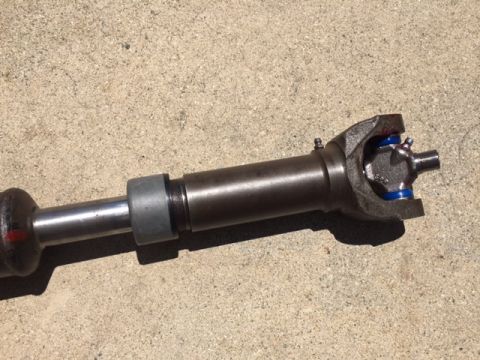 1978 Ford Bronco - Close-up of a driveshaft component, a U-joint with blue seals.