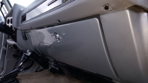 1995 Ford Bronco - The interior dashboard and glove box of a vehicle are shown in this close-up photo.