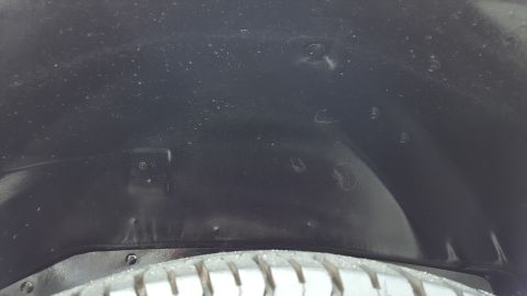 1995 Ford Bronco - Close-up view of a vehicle's wheel well liner, showing rivets and a portion of the tire.