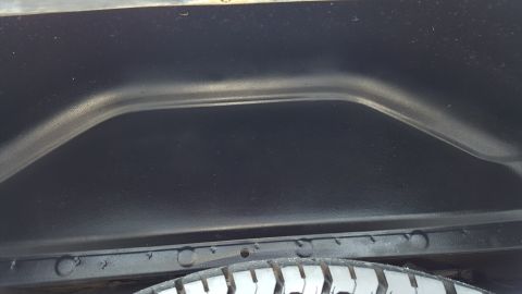 1995 Ford Bronco - Interior view of a vehicle's wheel well, showing the tire and undercarriage components.