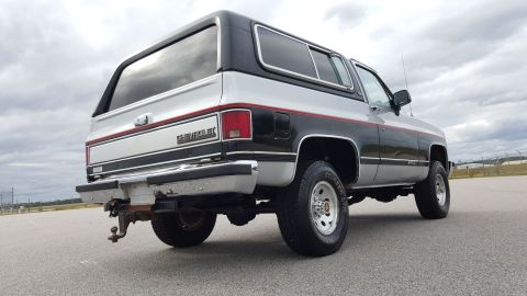 1995 Ford Bronco - Rear view of a two-tone silver and black 1981 Chevrolet K5 Blazer with a red stripe.