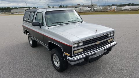 1995 Ford Bronco - This Chevrolet K5 Blazer features a two-tone paint scheme with a red pinstripe accent.