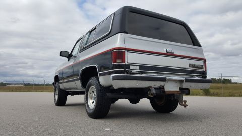 1995 Ford Bronco - Rear view of a two-tone silver and black Chevrolet K5 Blazer, likely from the 1980s.