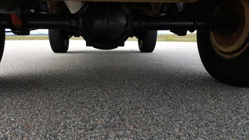 Underside view of a vehicle showing the rear axle, differential, and tires