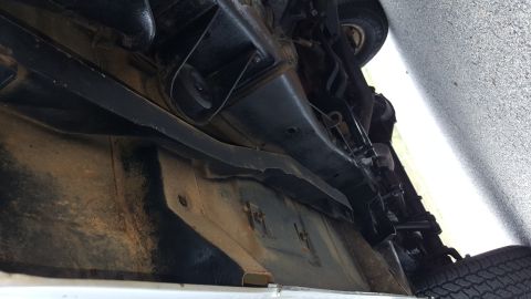 1995 Ford Bronco - The underside of a vehicle is shown, with visible frame components and suspension parts.