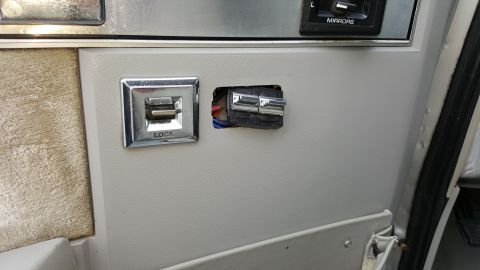 1995 Ford Bronco - Close-up of a car's interior door panel with window and lock controls visible.
