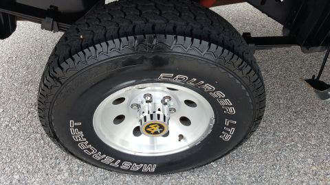 1995 Ford Bronco - A close-up view of a Mastercraft Courser LTR tire mounted on a silver alloy wheel, a distinctive center cap.