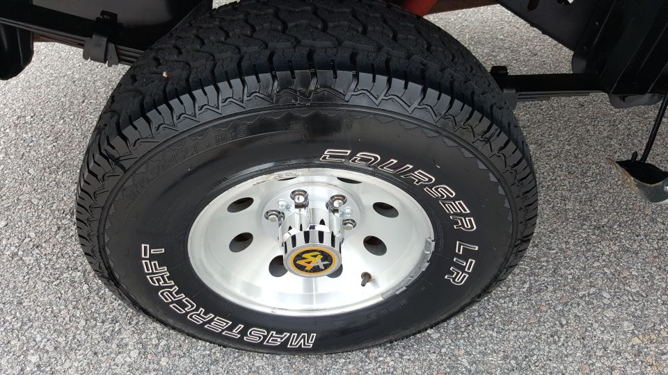 Mastercraft Courser LTR tire on a silver wheel with a yellow and black center cap
