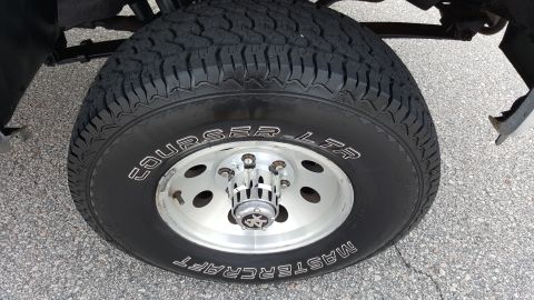 1995 Ford Bronco - Close-up of a Mastercraft Courser LTR tire on a silver wheel with a chrome hubcap.