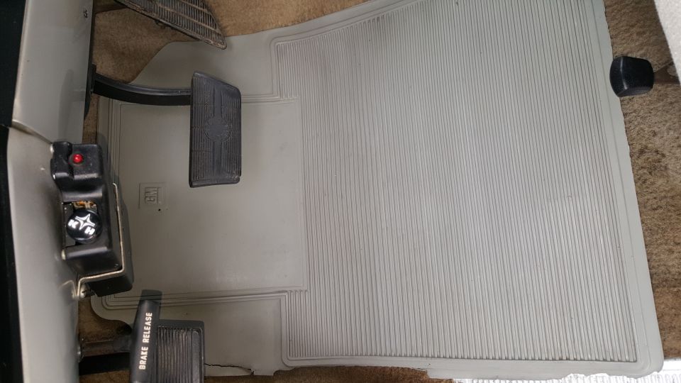 Vehicle interior floor showing brake and accelerator pedals, and a "BRAKE RELEASE" lever