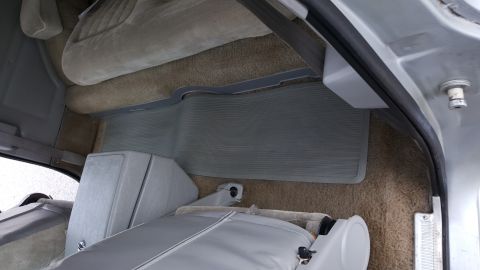 1995 Ford Bronco - The rear interior cargo area of a vehicle, showing carpeted flooring and folded seats.