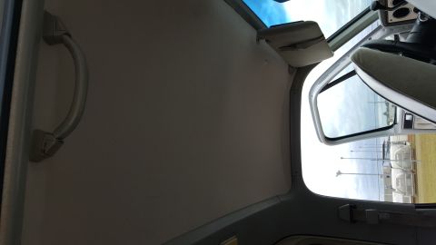 1995 Ford Bronco - Interior view of a vehicle, focusing on the grab handle and the open door revealing the exterior.