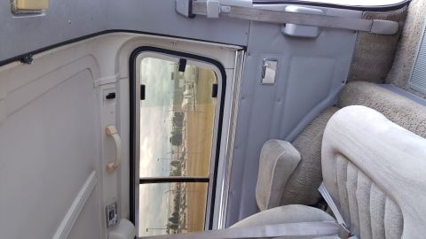 1995 Ford Bronco - Interior view of a van or RV, showing the door frame, a seat, and carpeted walls.