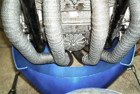 1985 Ford Crown Victoria LTD - Close-up view of exhaust pipes and engine components, with a blue fairing in the foreground.