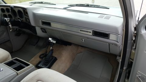 1995 Ford Bronco - Interior view of a truck's dashboard and center console, a CB radio mounted on the shifter.