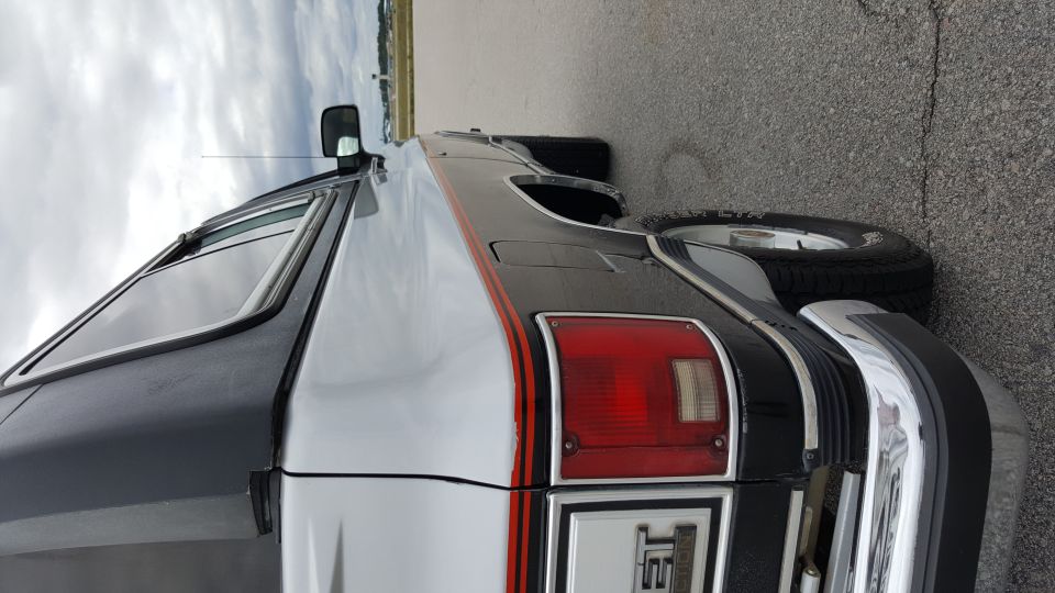 Rear quarter of a black and silver SUV with a red taillight and chrome bumper. Visible text reads 'JET'