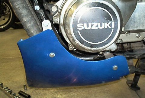 1985 Ford Crown Victoria LTD - Close-up of a blue fairing mounted on the engine of a Suzuki motorcycle.