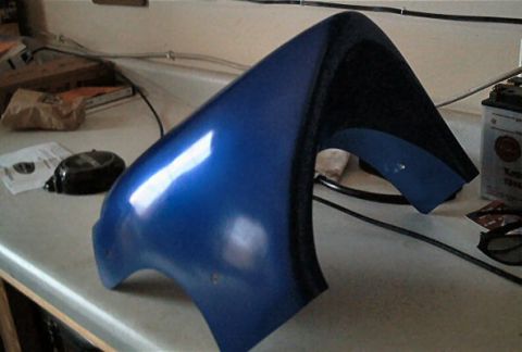 1985 Ford Crown Victoria LTD - Unidentified blue automotive part on a counter, possibly a fender or fairing.