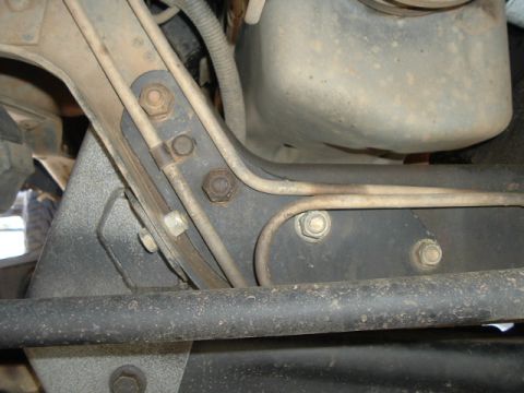 1989 Ford Bronco - Close-up view of the underbody TTB bracket, showing brake lines and fasteners.