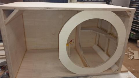 1994 Ford Bronco - A custom-built wooden enclosure designed for a subwoofer, showing its internal structure and speaker mounting hole.