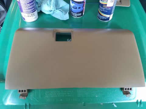 1994 Ford Bronco - A tan glove box door is shown with spray cans and rags nearby, suggesting a repair or cleaning project.
