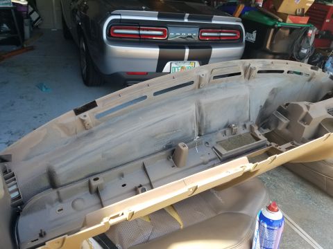 1994 Ford Bronco - A tan dashboard part is shown in a garage, with a Dodge Challenger visible behind it.