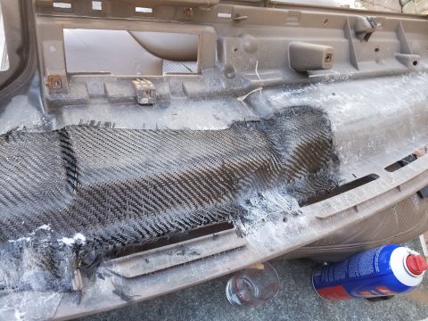 1994 Ford Bronco - Dashboard panel undergoing repair with carbon fiber reinforcement, with a spray can and glass nearby.