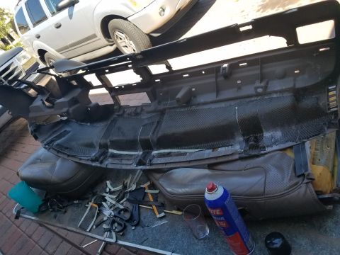 1994 Ford Bronco - A disassembled car dashboard is laid out with tools and supplies, with another vehicle visible in the background.