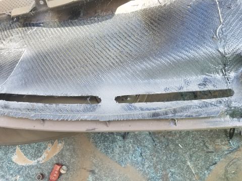 1994 Ford Bronco - Dashboard panel covered in carbon fiber weave, showing cutouts for air vents and signs of repair work.