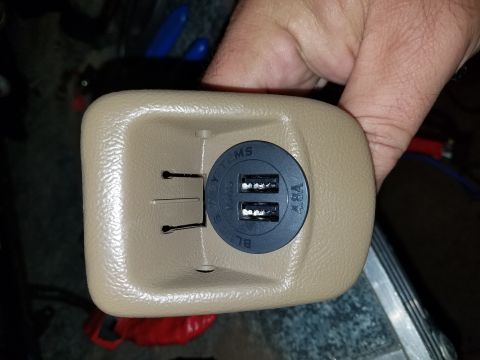 1994 Ford Bronco - This is a close-up of a vehicle's interior part, showing a newly installed dual USB charging port.