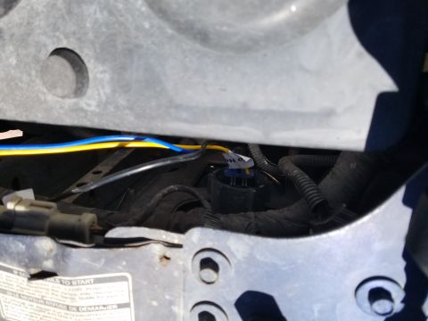 1994 Ford Bronco - Detail of the wiring harness and a relay in the engine bay, possibly for headlight circuits.