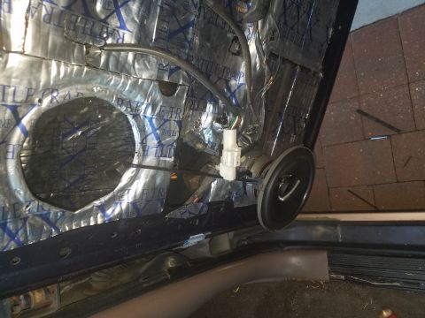 1994 Ford Bronco - Interior of a car door with sound deadening and speaker installation in progress.