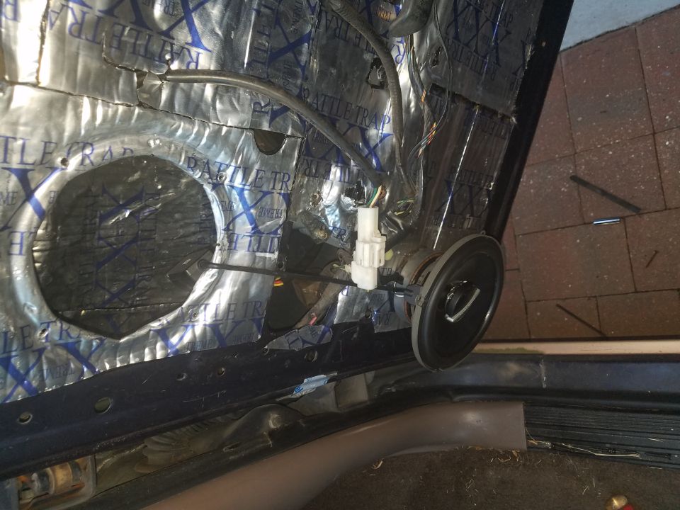 Car door panel removed showing sound deadening material and speaker wiring