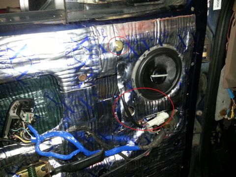 1994 Ford Bronco - Interior view of a car door panel showing sound dampening material, a speaker, and exposed wiring.