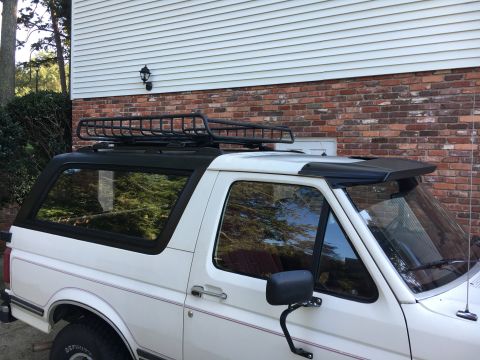 1988 Ford Bronco - White 1988 Ford Bronco with a black roof rack and aftermarket visor parked outside.