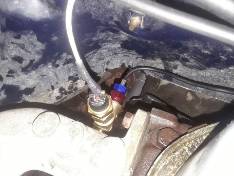 1985 Ford Bronco - Close-up view of an engine temperature sensor with associated wiring and fittings.